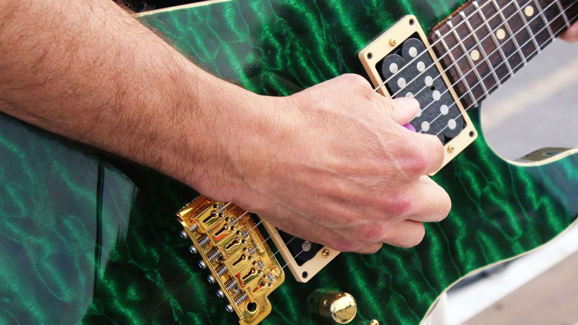 Bild einer grünen Egitarre mit Hand