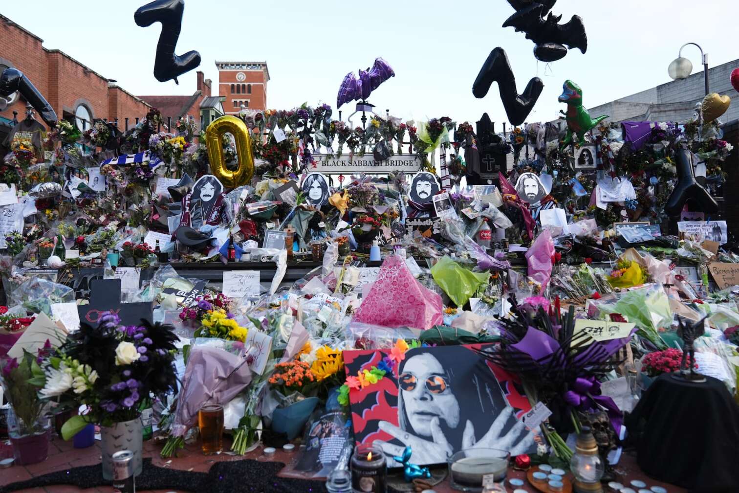 30.07.2025, Großbritannien, Birmingham: Fans beobachten den Leichenwagen mit Ozzy Osbourne auf der Broad Street. Der Leichnam des Black-Sabbath-Frontmanns wird nach seinem Tod letzte Woche im Alter von 76 Jahren zu einer Prozession in seine Heimatstadt gebracht. Foto: Joe Giddens/PA Wire/dpa +++ dpa-Bildfunk +++