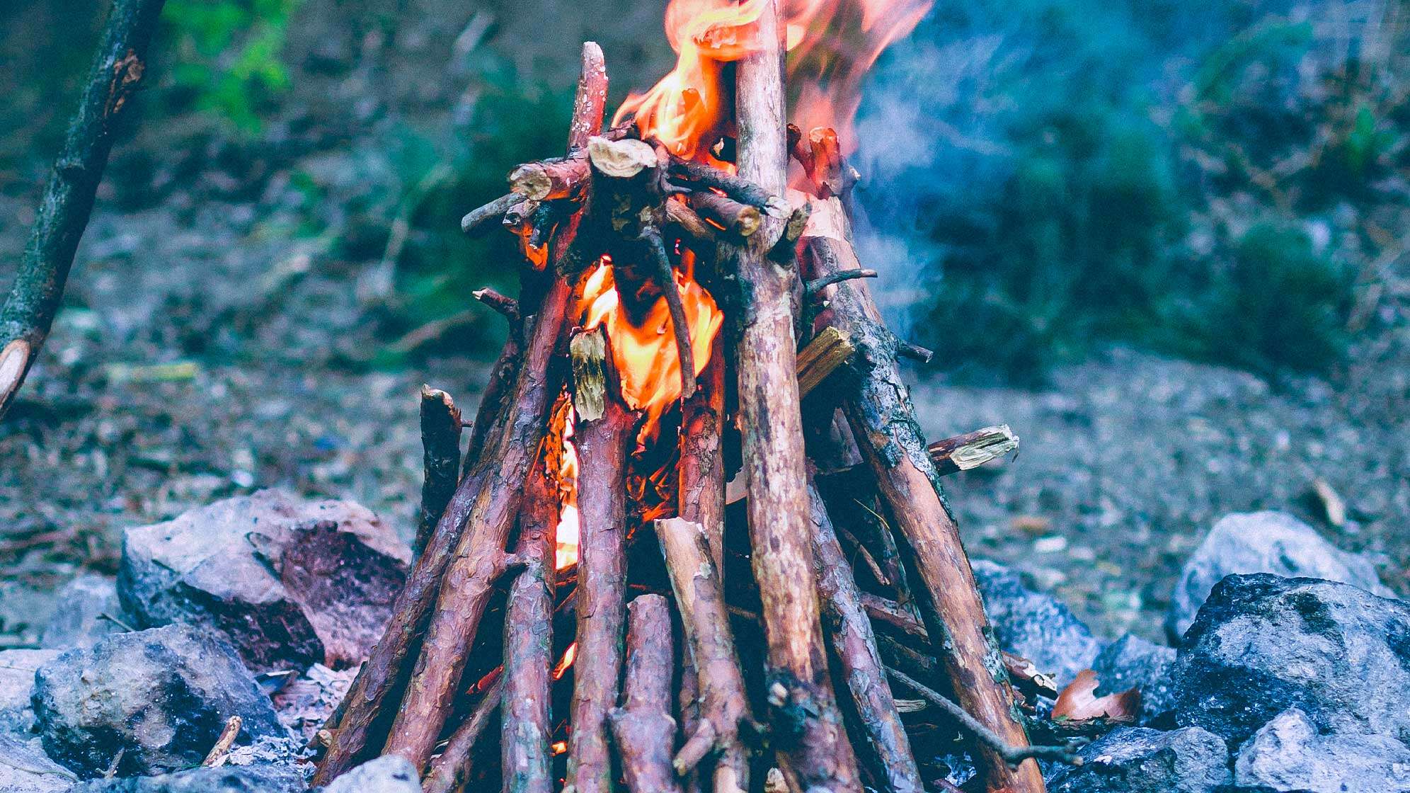 Äste, die pyramidenförmig zu einem Lagerfeuer aufgeschichtet wurden.