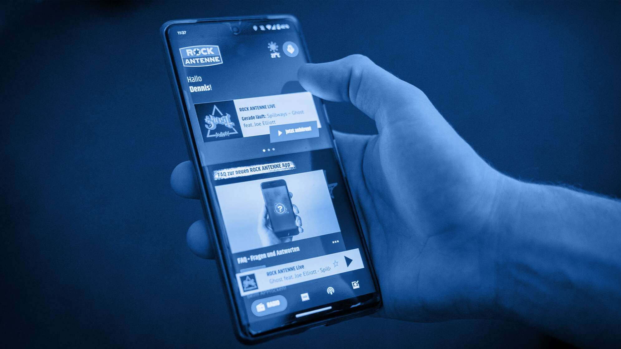 Eine Hand mit Smartphone, auf dem Screen zu sehen ist die neue ROCK ANTENNE App