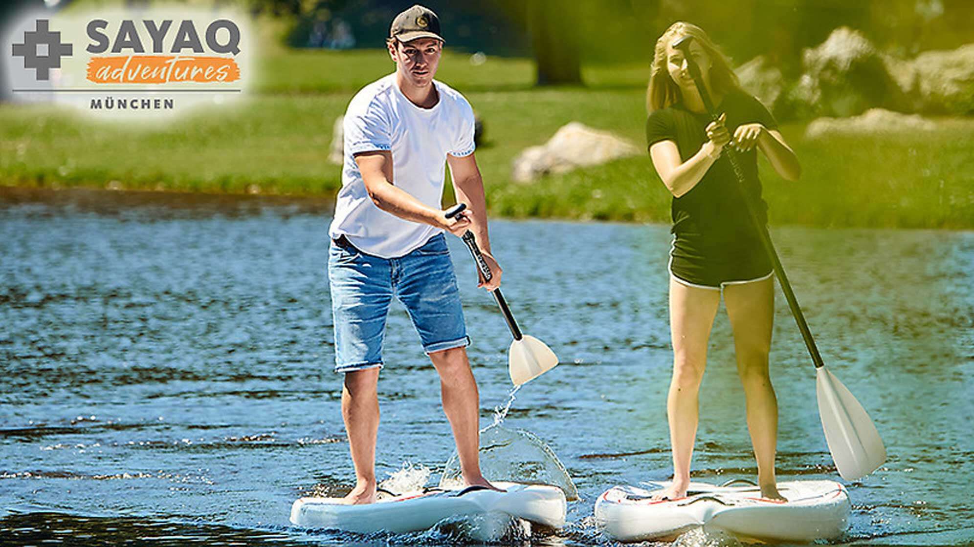 Ein Mann und eine Frau stehen auf einem Stand Up Board und paddeln im Wasser
