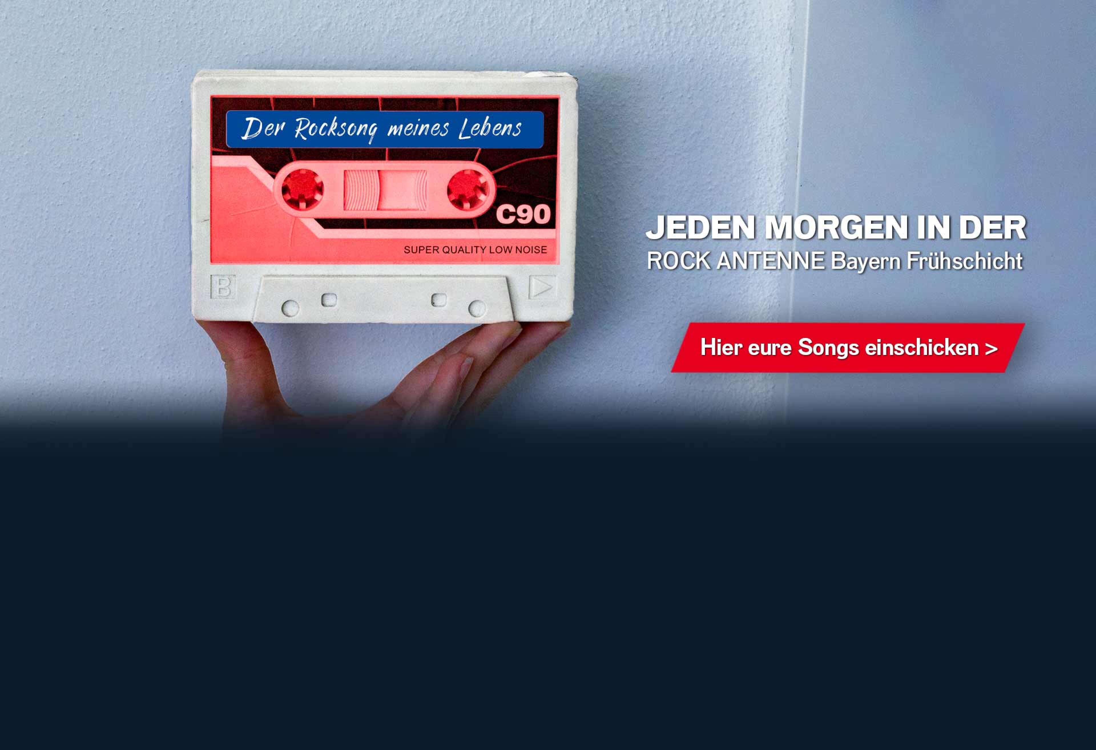 Hand, die eine Kassette hochhält, darauf das Label "Der Rocksong meines Lebens", dazu Text: "Jeden Morgen in der ROCK ANTENNE Bayern Frühschicht - Hier eure Songs einschicken >"