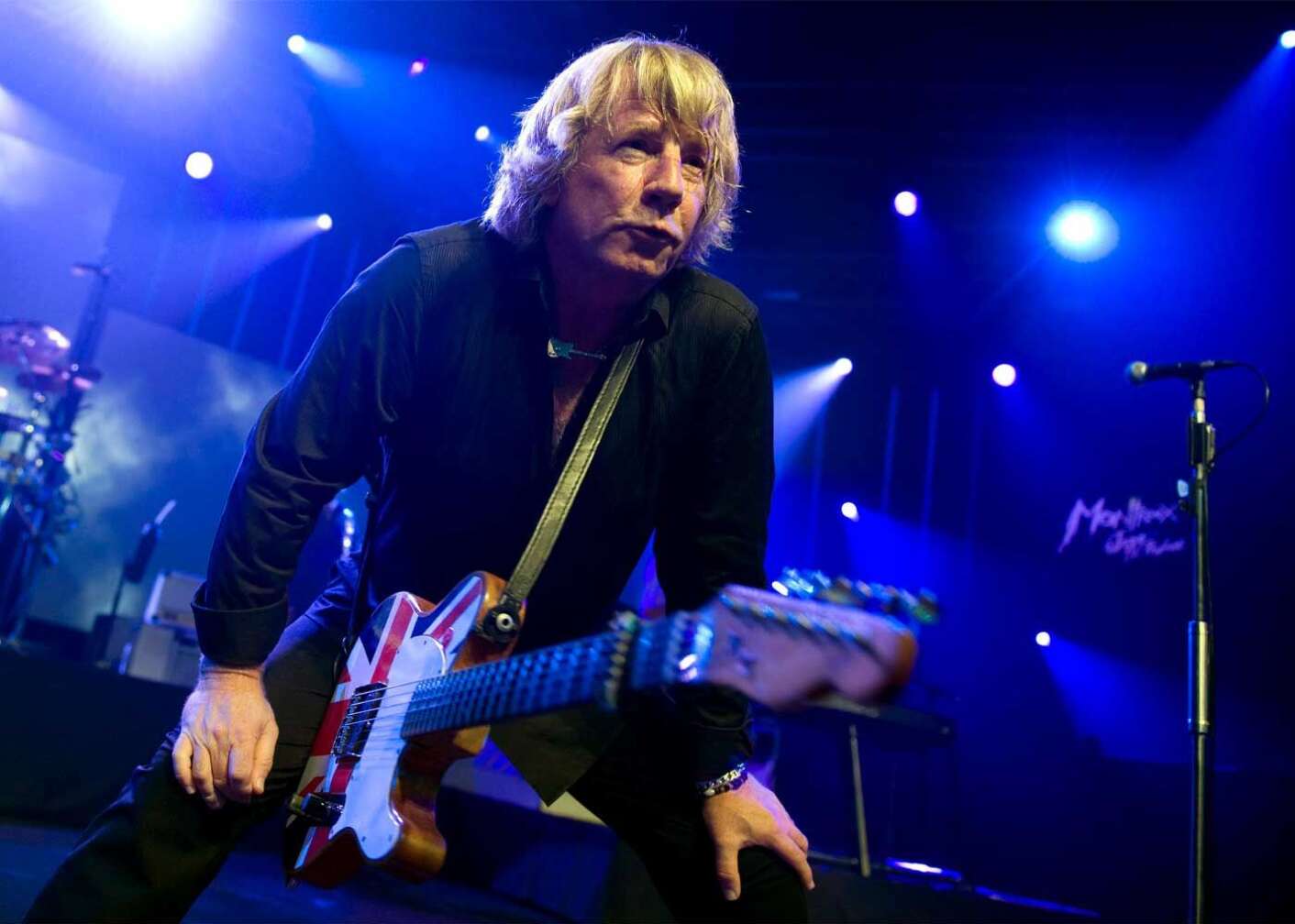 Rick Parfitt auf der Bühne nach vorne lehnend